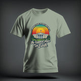 Sage green t-shirt with a graphic of the White House, a retro sunset, and text.