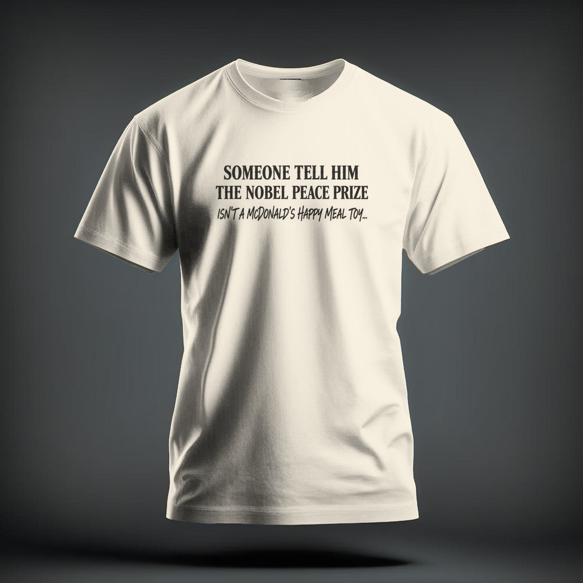 Off-white crewneck t-shirt featuring black text reading "SOMEONE TELL HIM THE NOBEL PEACE PRIZE ISN'T A MCDONALD'S HAPPY MEAL TOY..." on the chest.