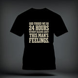 A black t-shirt printed with the beige text God forbid we go 24 hours without hearing about this man's feelings.