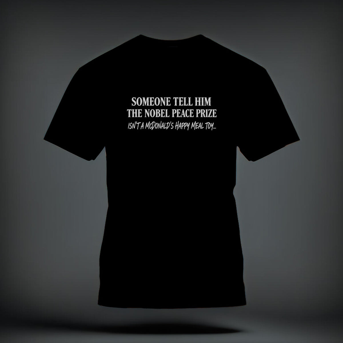 A black t-shirt printed with the white text: "SOMEONE TELL HIM THE NOBEL PEACE PRIZE ISN'T A MCDONALD'S HAPPY MEAL TOY..."