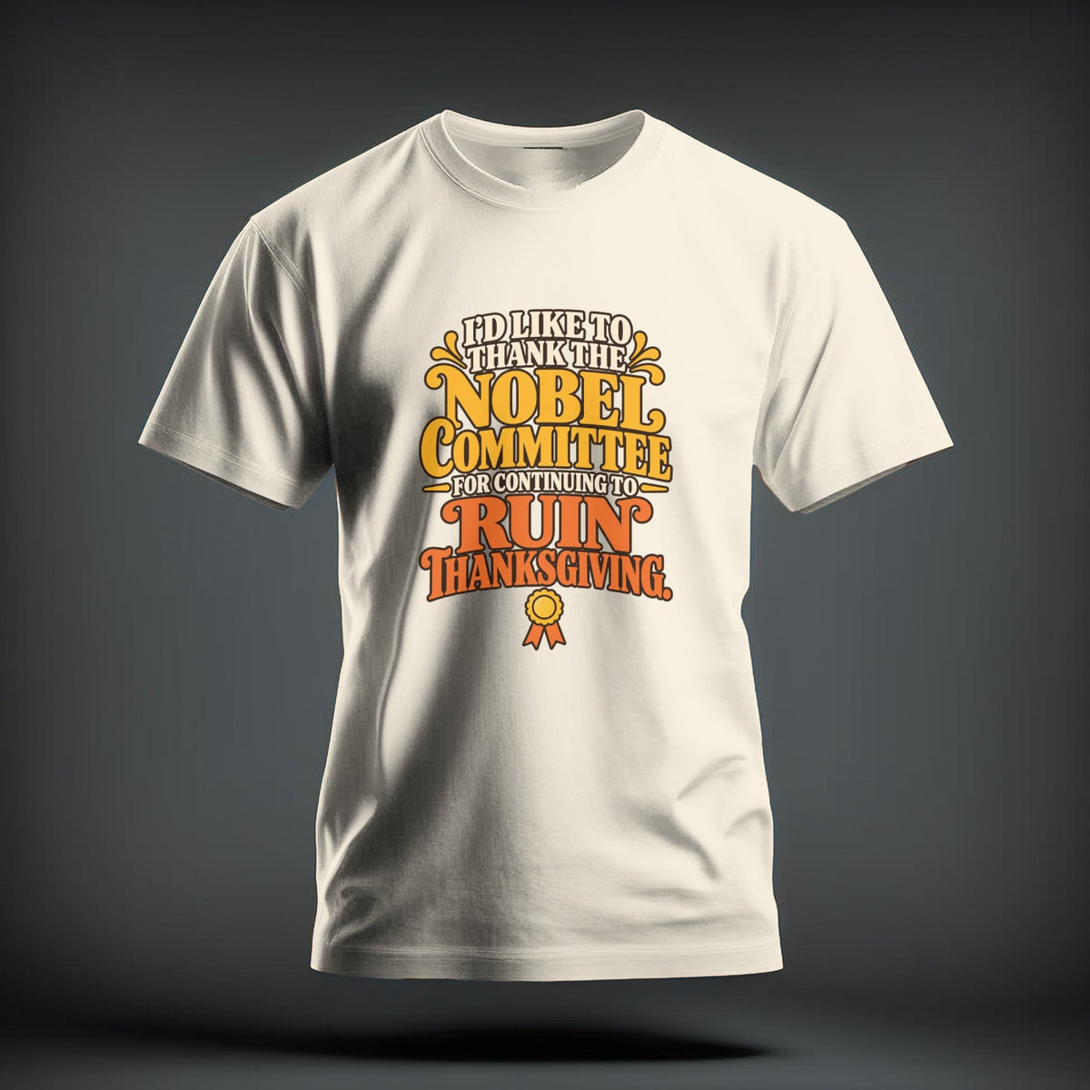 A cream-colored t-shirt with brown and orange typography reading, I'd like to thank the Nobel Committee for continuing to ruin Thanksgiving.
